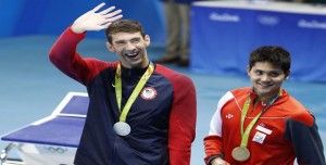 Silver medallist USA's Michael Phelps (L) waves nex to gold medallist Singapore's Schooling Joseph during the medal ceremony of the Men's 100m Butterfly Final during the swimming event at the Rio 2016 Olympic Games at the Olympic Aquatics Stadium in Rio de Janeiro on August 12, 2016. / AFP / Odd Andersen (Photo credit should read ODD ANDERSEN/AFP/Getty Images)